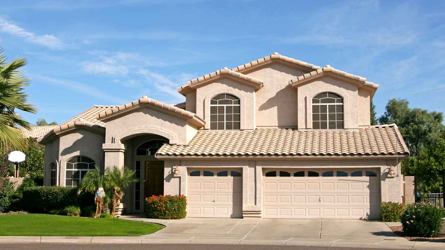 A three-car garage stucco house with a tile roof