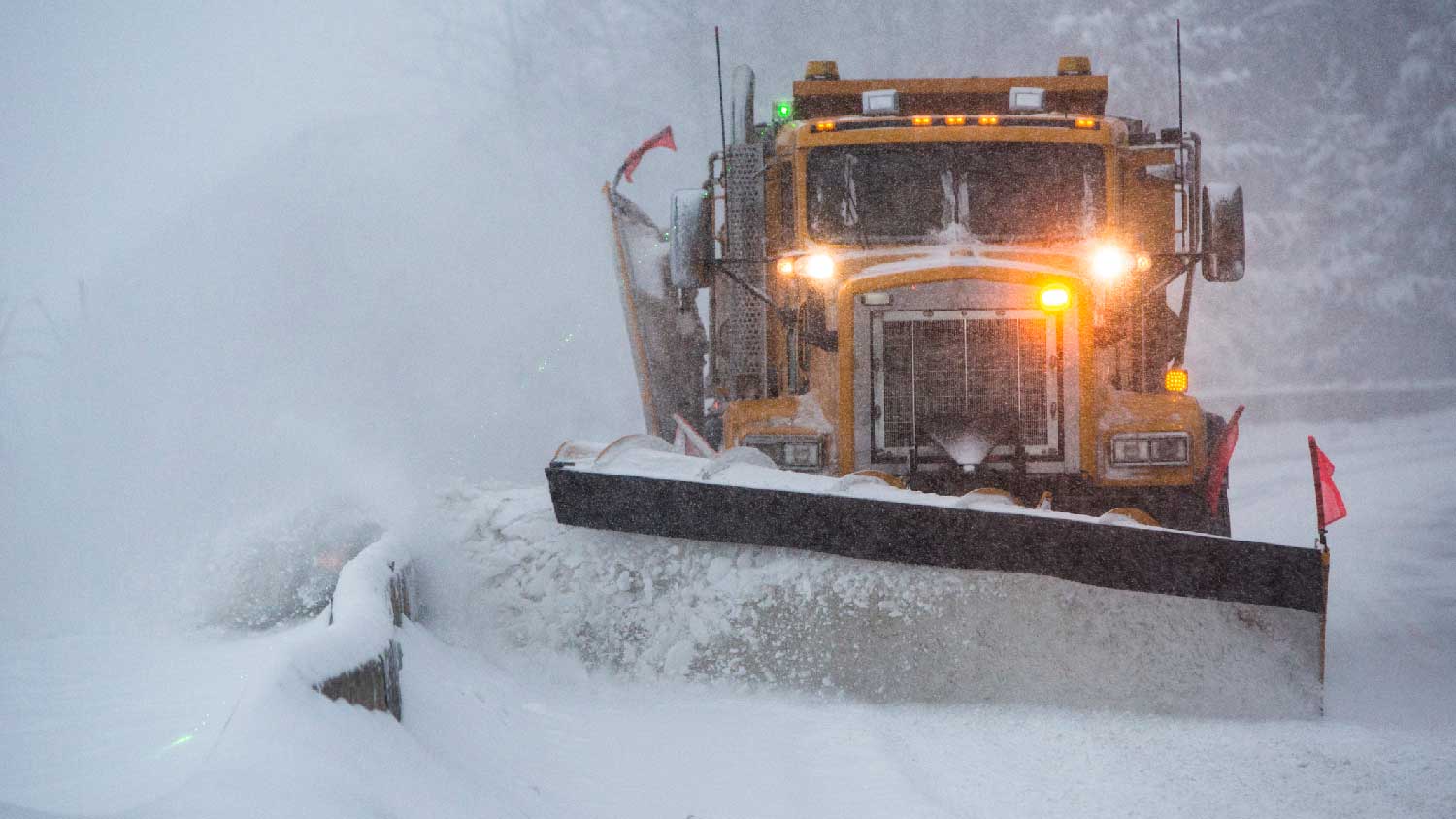 A large utility vehicle plowing the snow