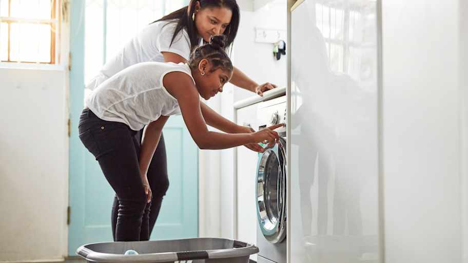 mother and daughter doing washing at home