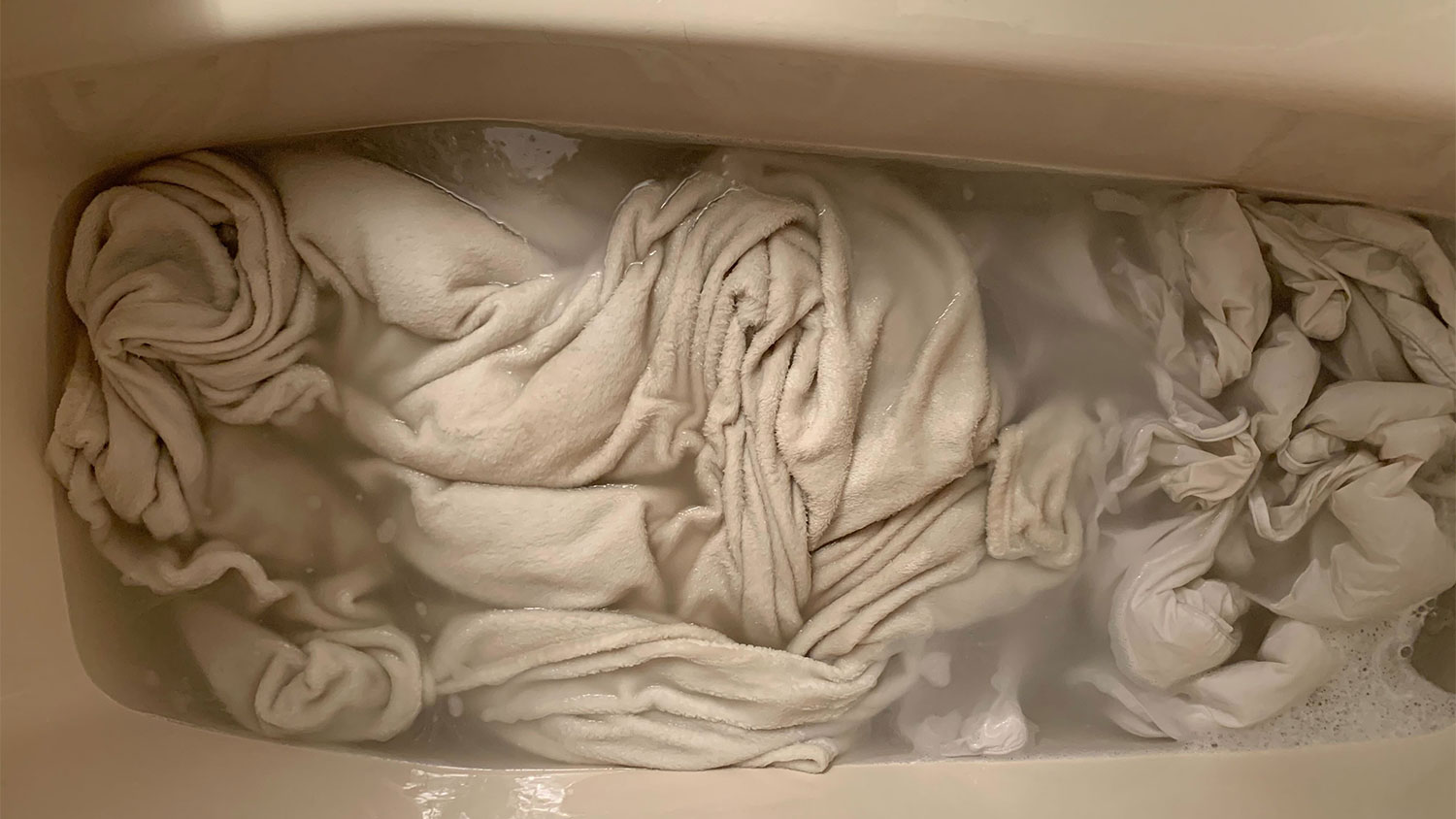 A view of laundry soaking in a tub