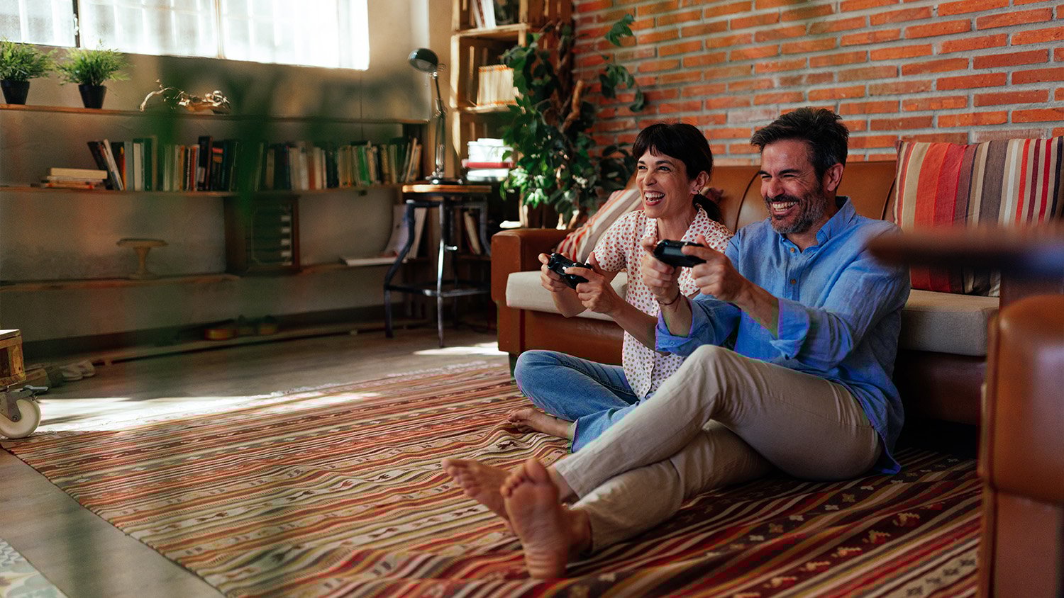 couple sitting on a rug playing video games