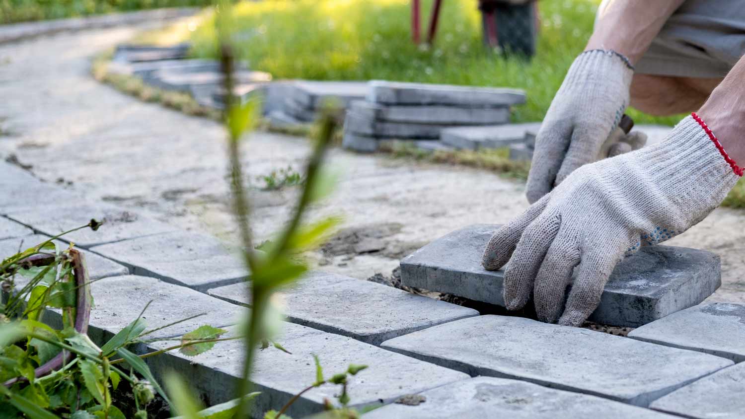 man laying paving stones in cement 