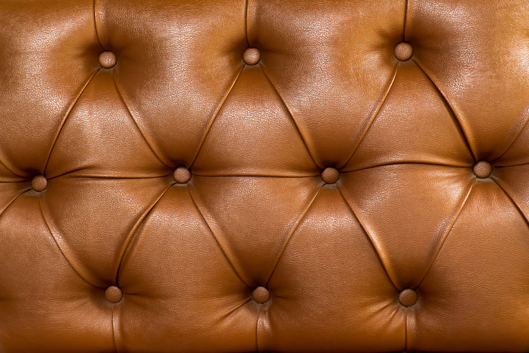 closeup of leather upholstery with multiple buttons
