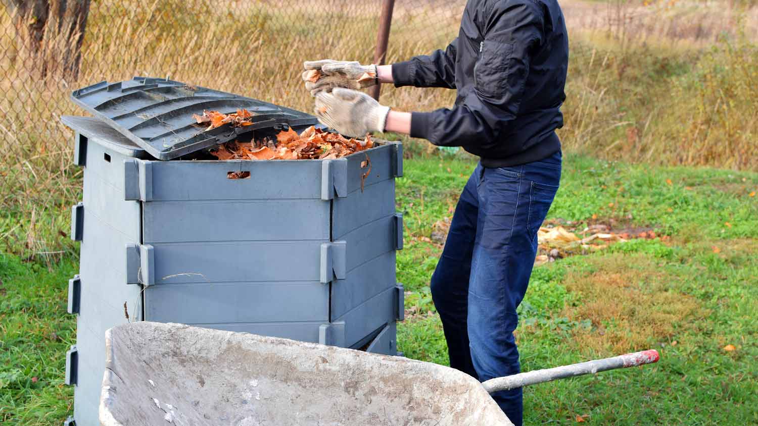 man throwing leaves in composting container