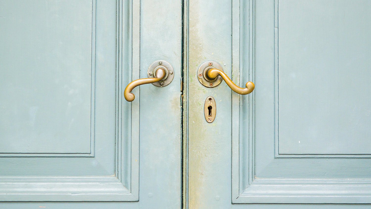 A lever handleset on a wooden blue front door