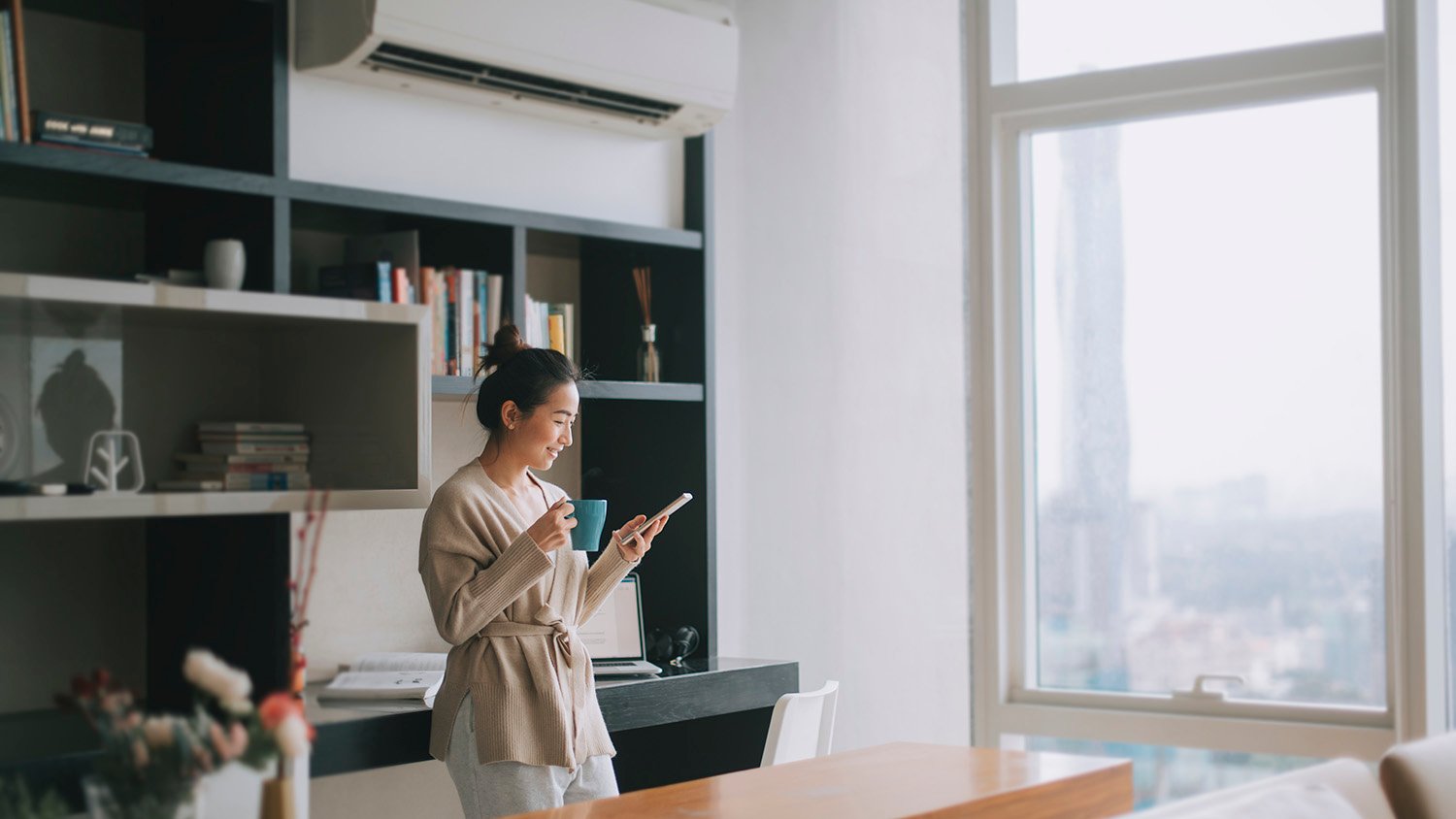 woman looking at phone while inside her house