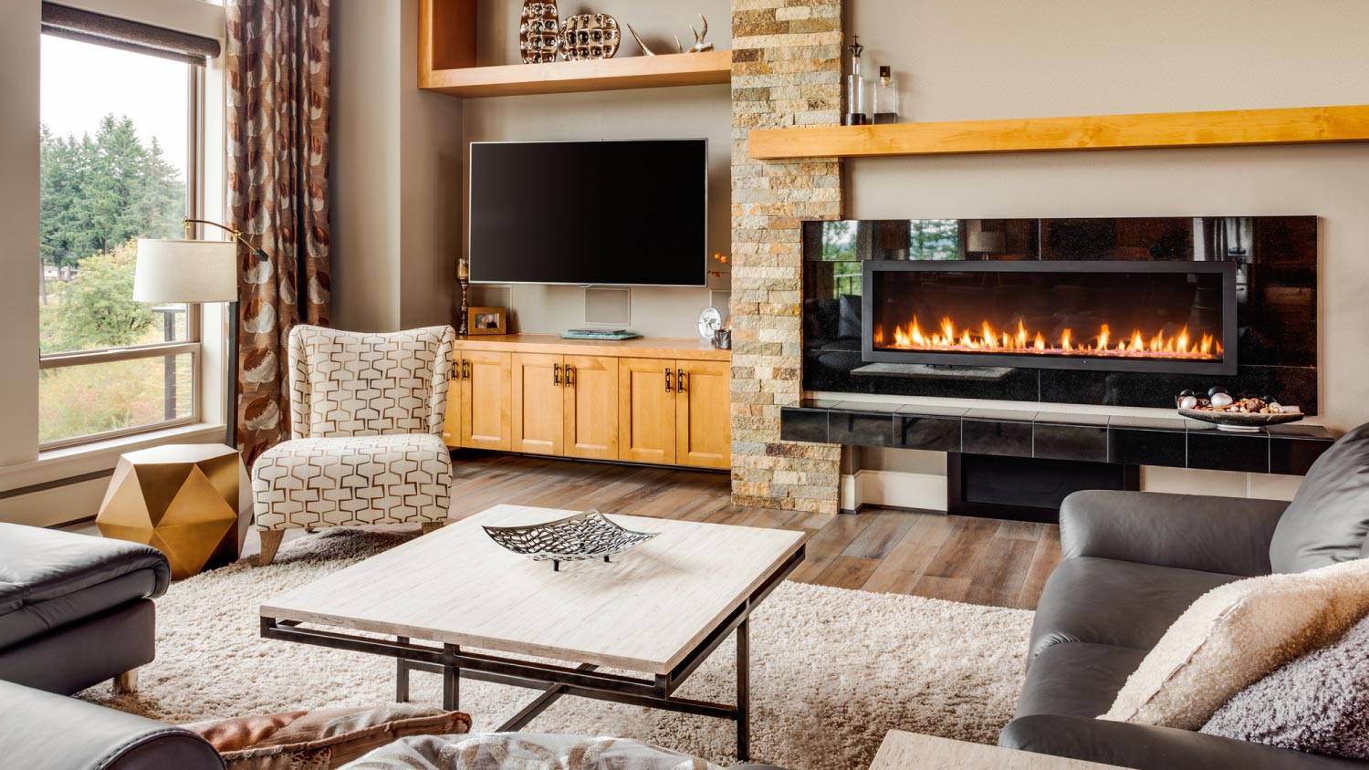 A living room in luxury home with fireplace and TV