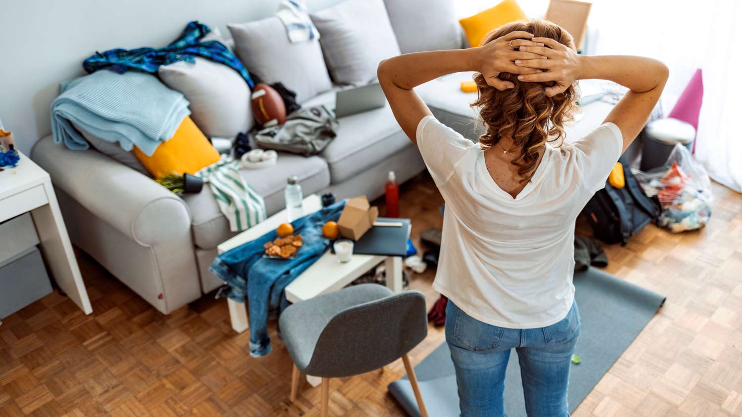 woman in living room full of clutter 