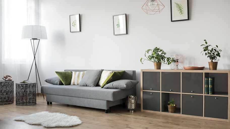 A living room with a drywall behind the sofa