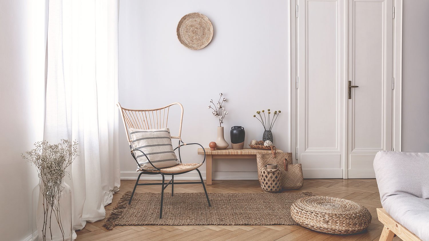Modern living room with sheer curtains and a wicker chair