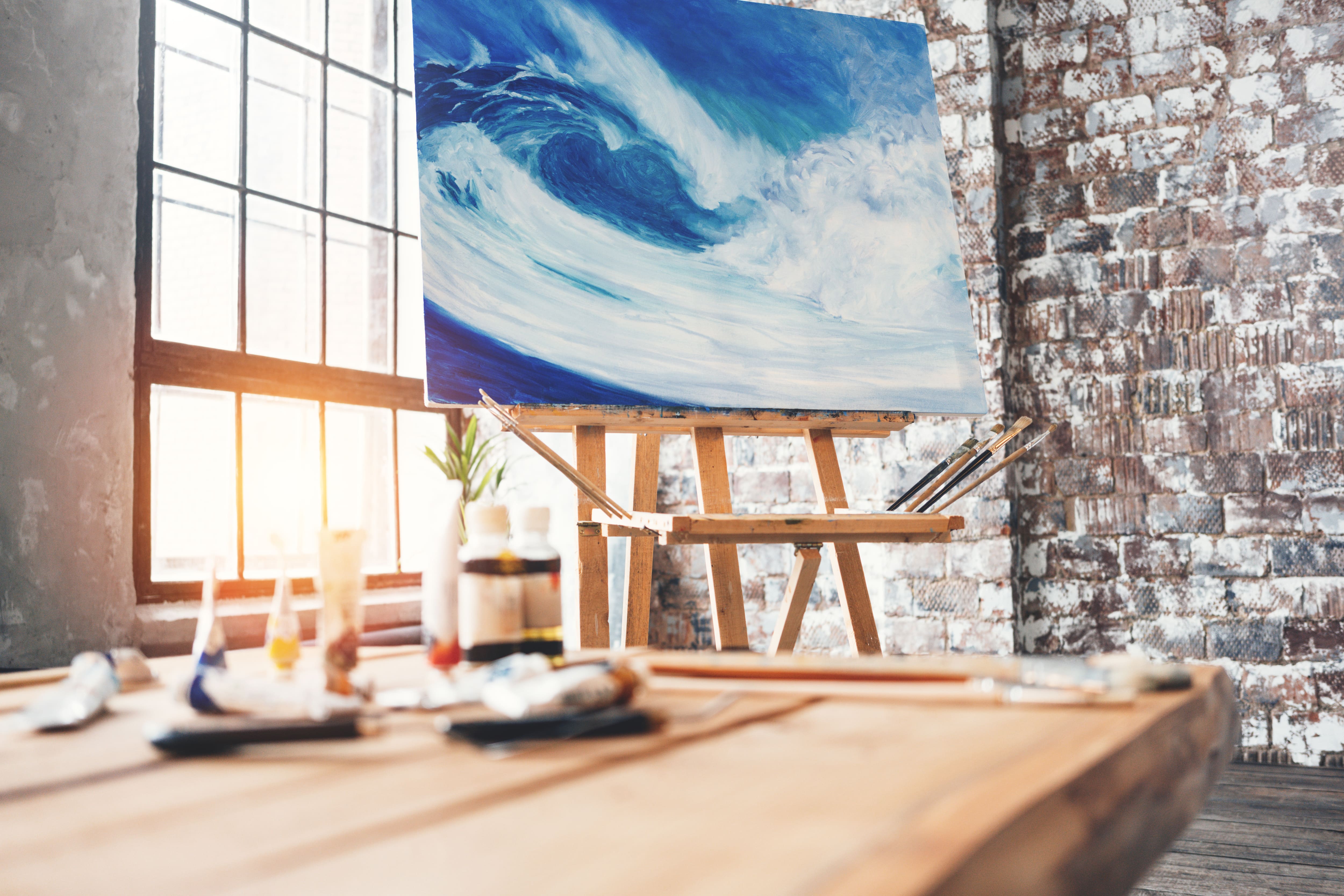 The corner of a loft apartment with a painting on an easel
