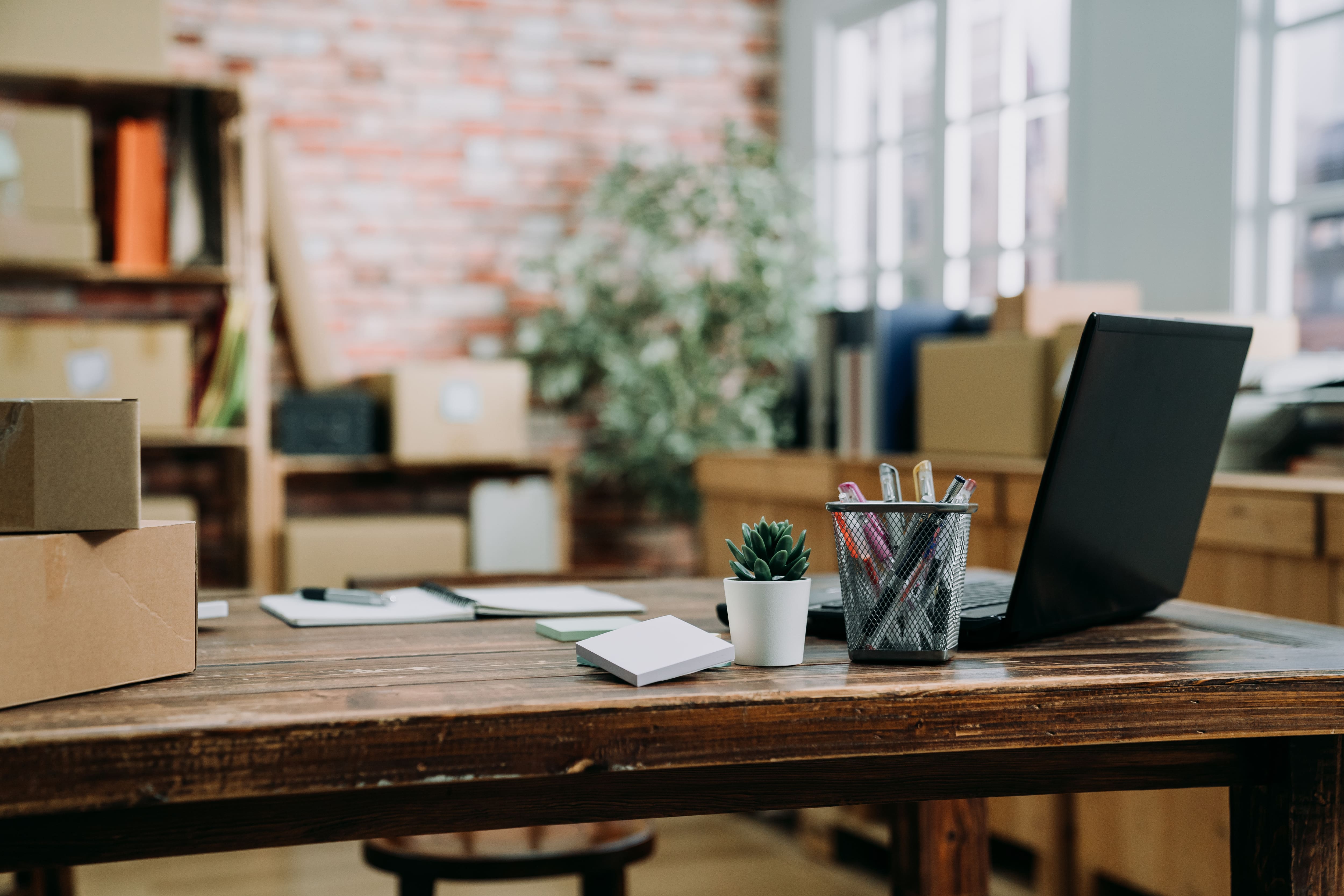 Close up of a wooden desk with a laptop on it