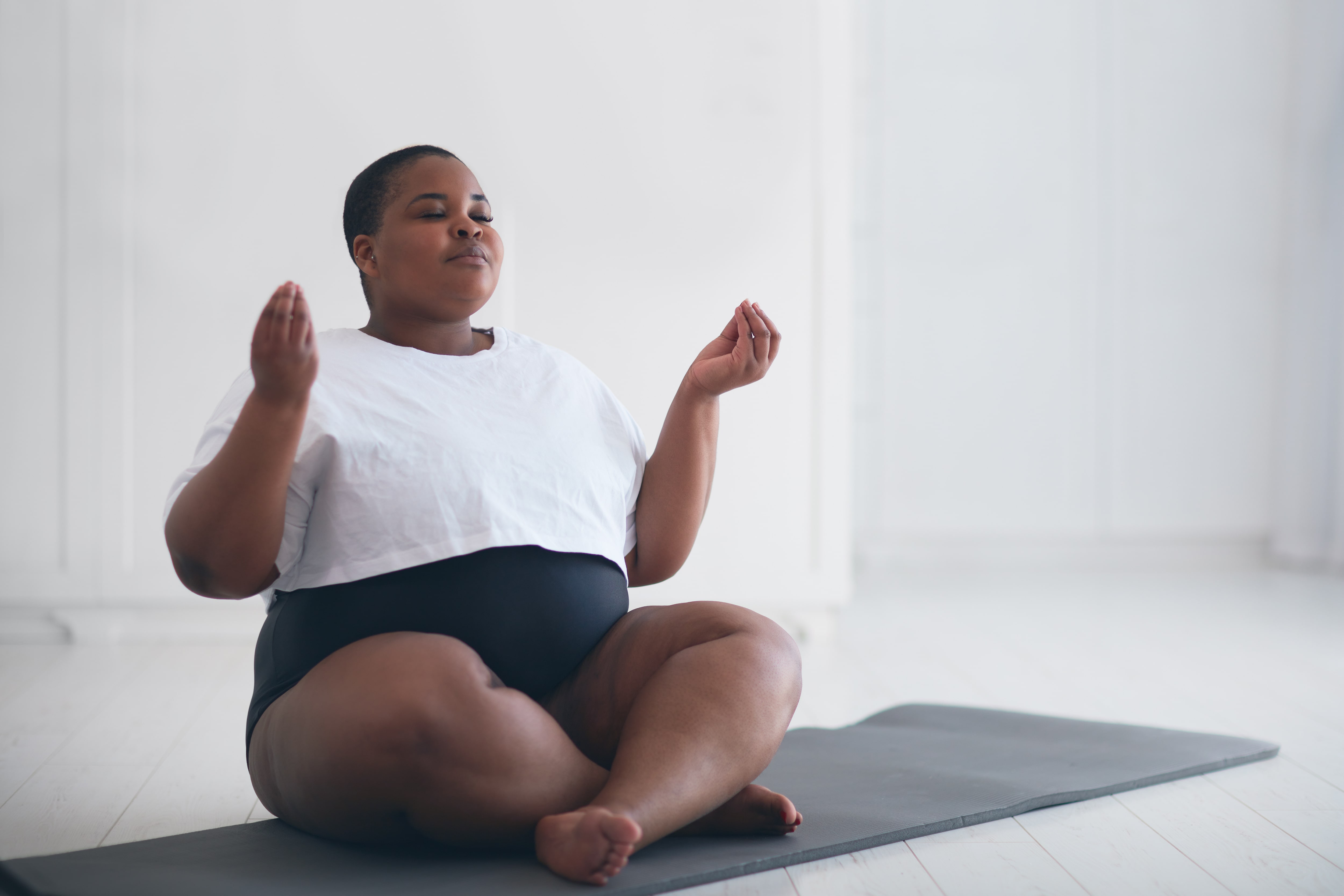 A loft room with a woman doing yoga on a mat