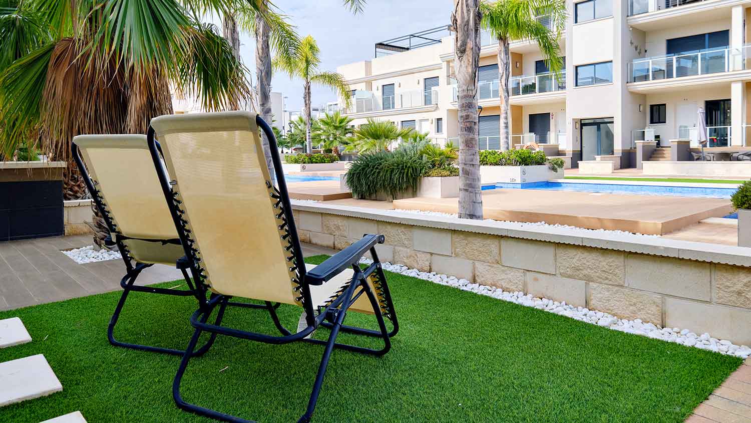 Lounge chairs on a patio with artificial grass