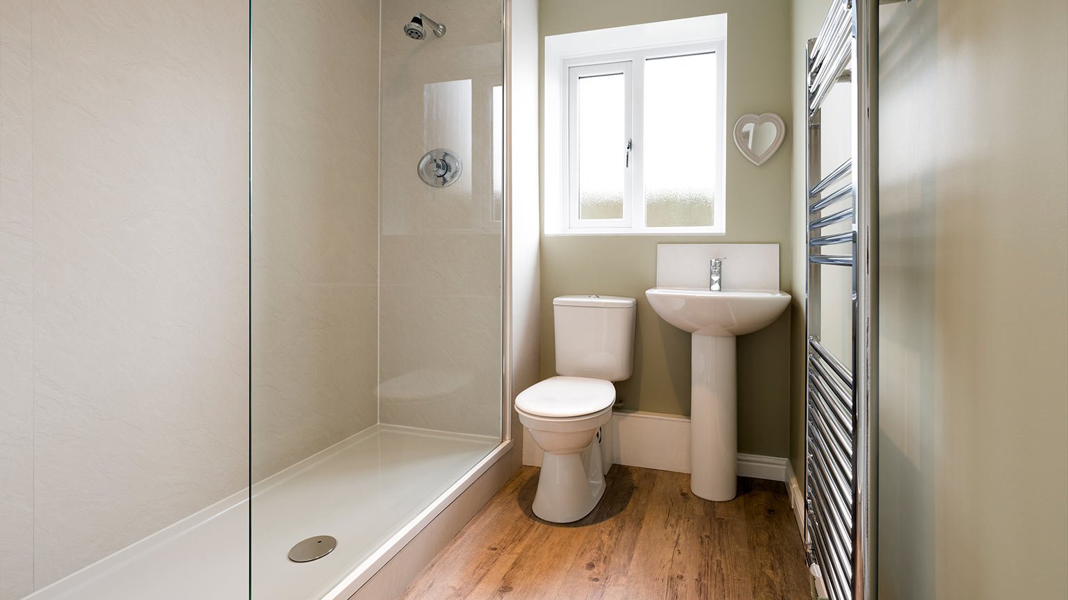 Modern compact bathroom with natural light and walk-in shower