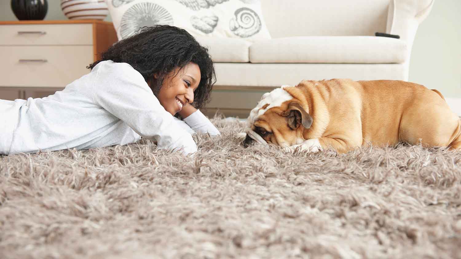 Woman and dog lying on a rug