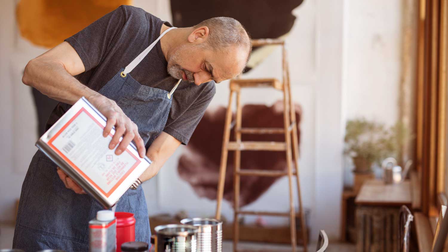 A man adding additive to a paint bucket