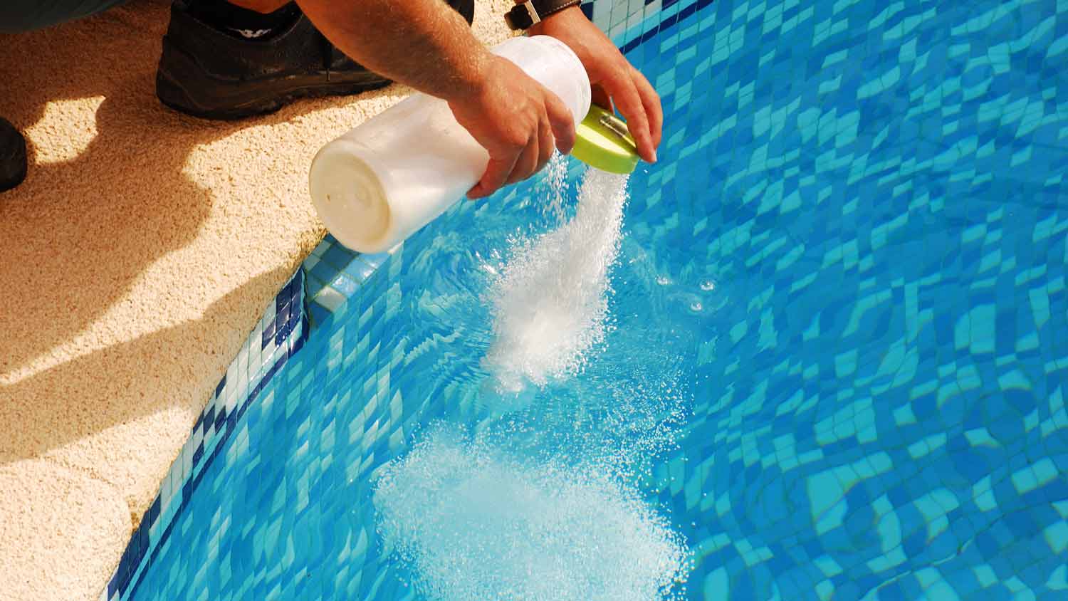  A man adding calcium to a pool