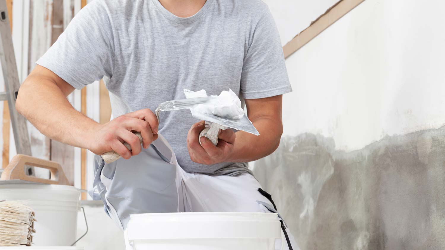 A man adding gypsum plaster on trowel