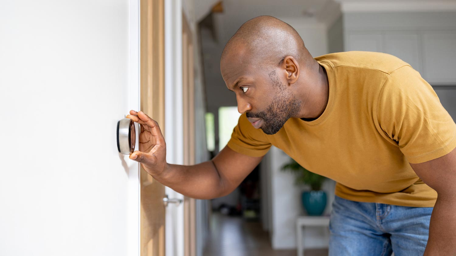 A man adjusting the temperature on a thermostat