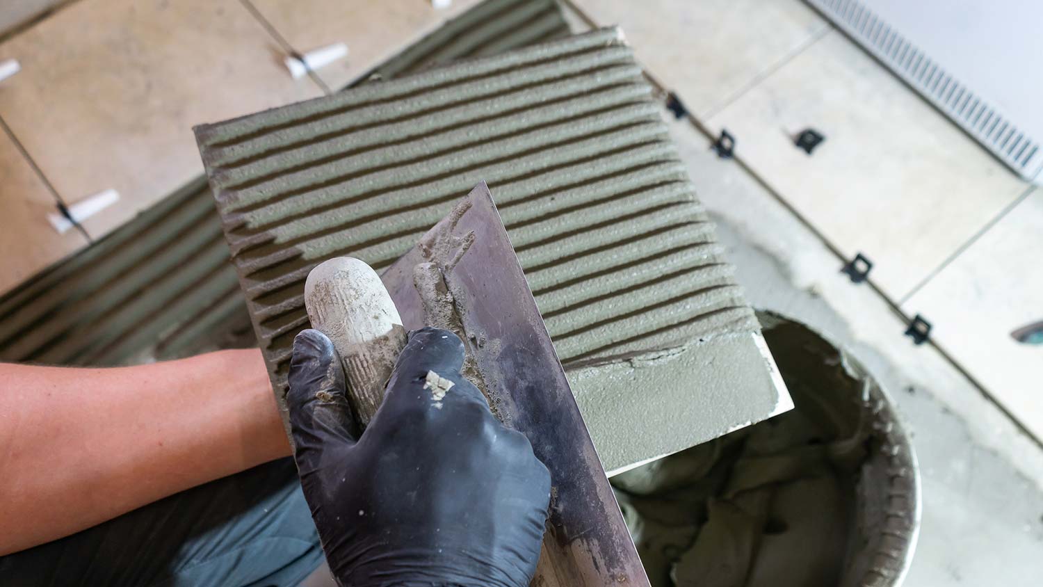 A man applying thinset on a tile