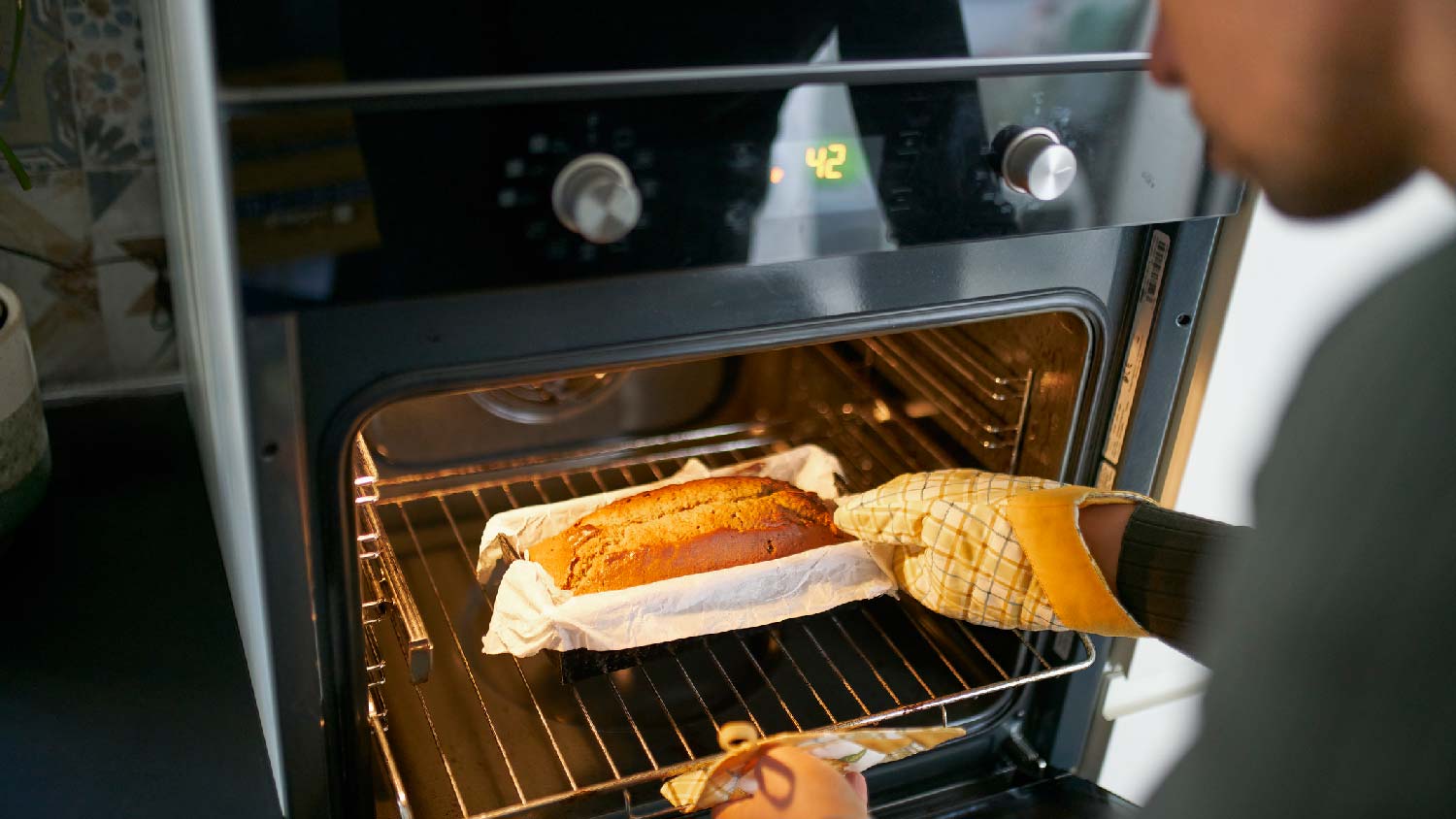 A man baking a cake in the oven