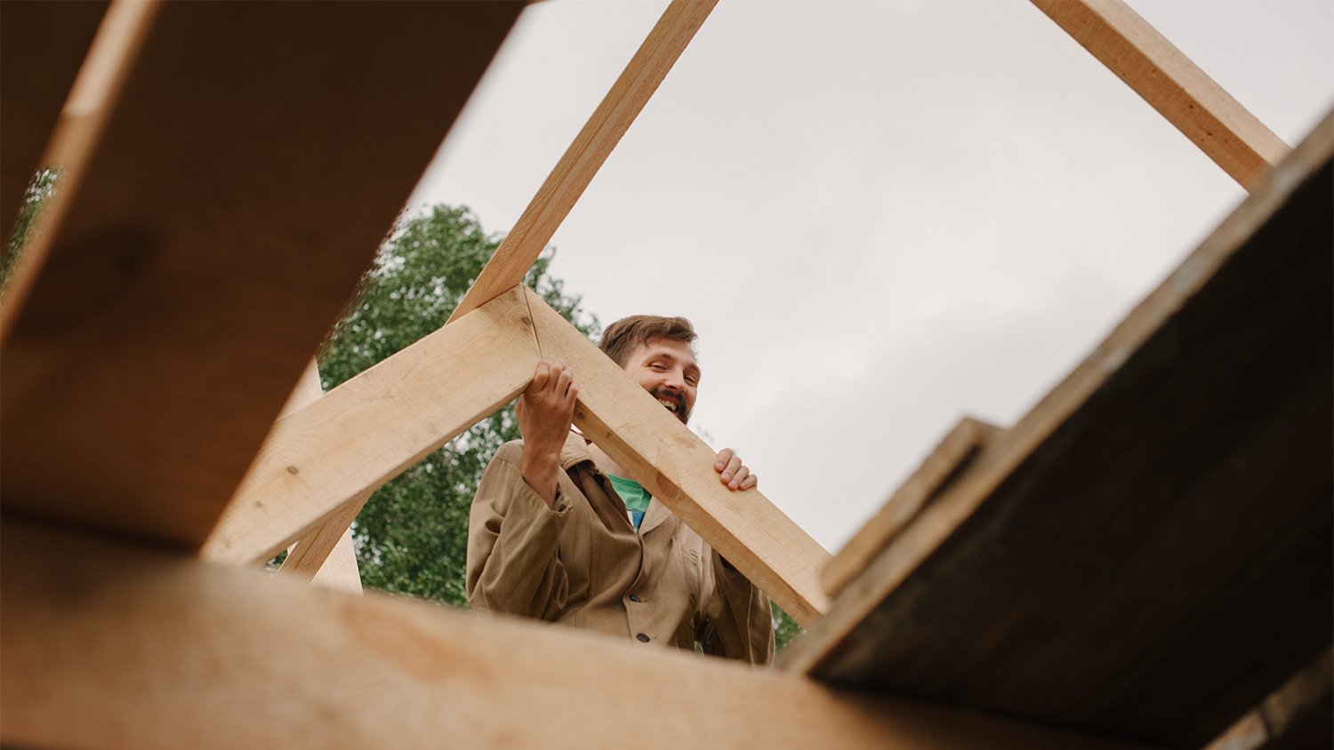 Man building wooden roof