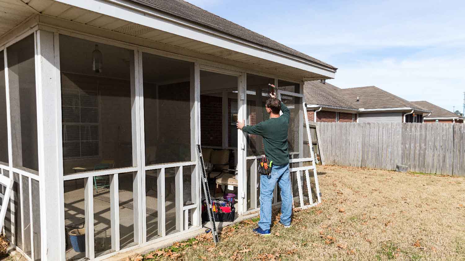 A man building a screened-in porch