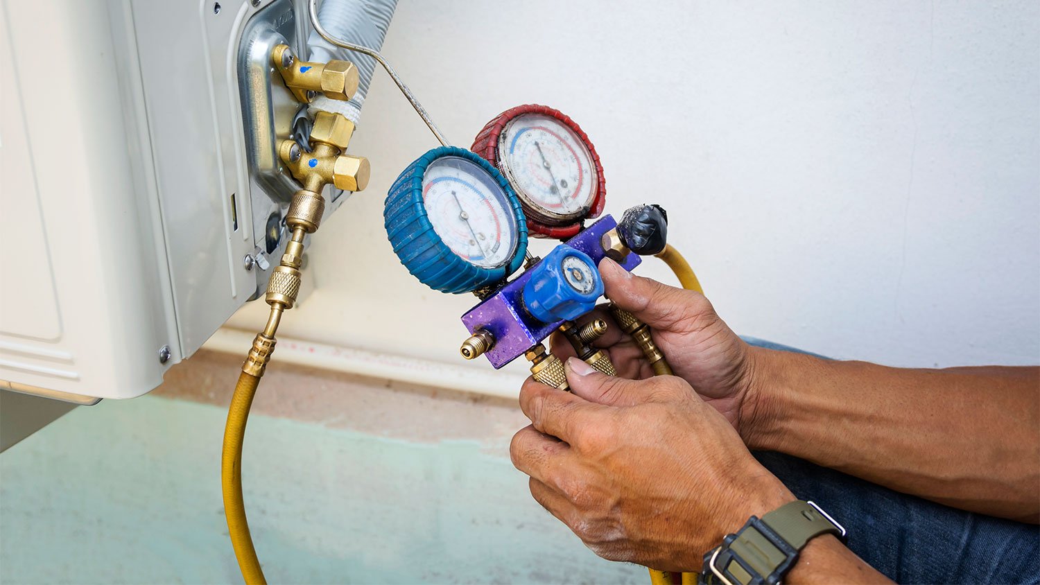 A man checks an air conditioner