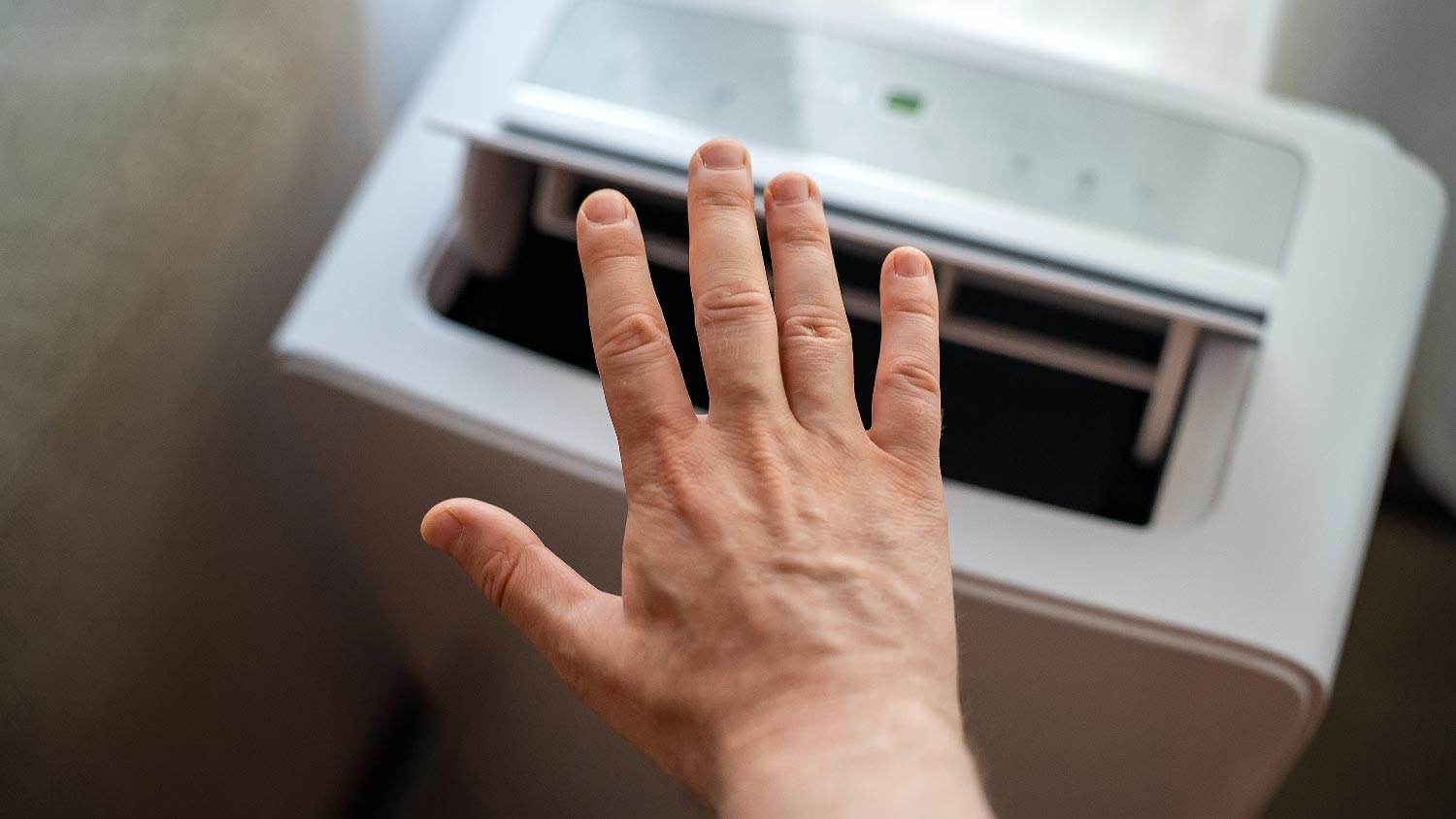 A man checking the air flow of a portable AC