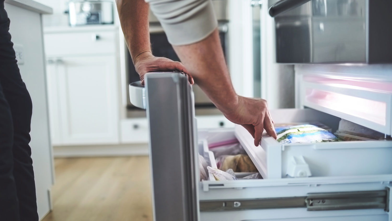 A man checking his freezer