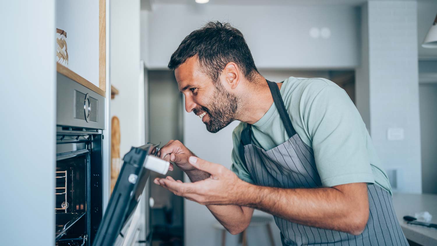 A man checking the inside of the oven