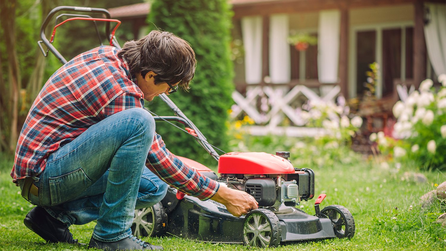 man doing a maintenance check on lawn mower