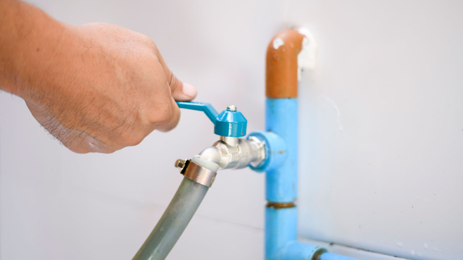 A man checking a water valve
