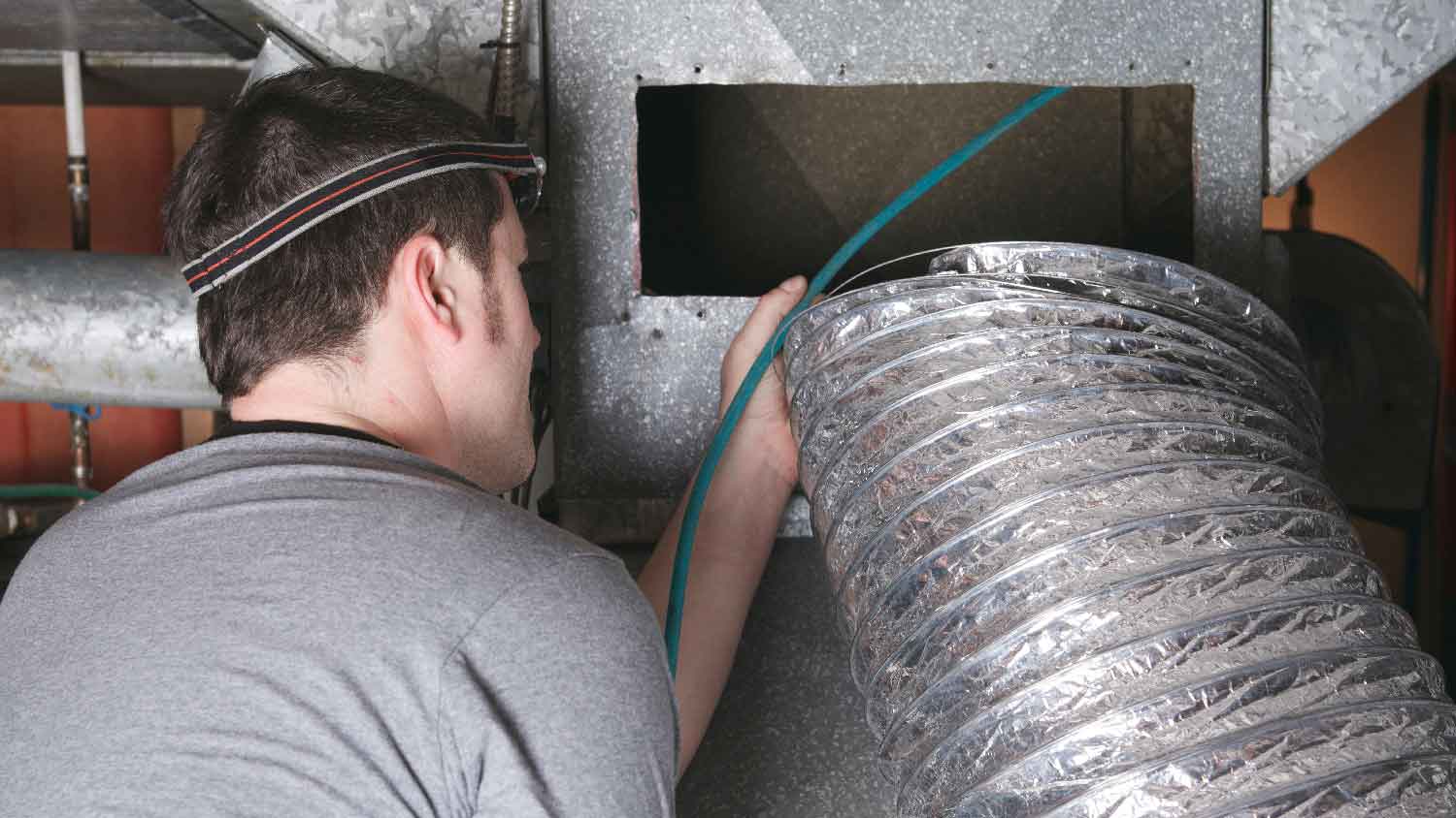 A man cleaning an air duct
