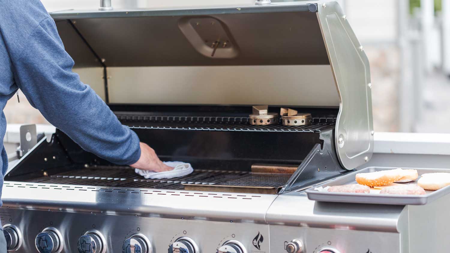 A man cleaning the grill