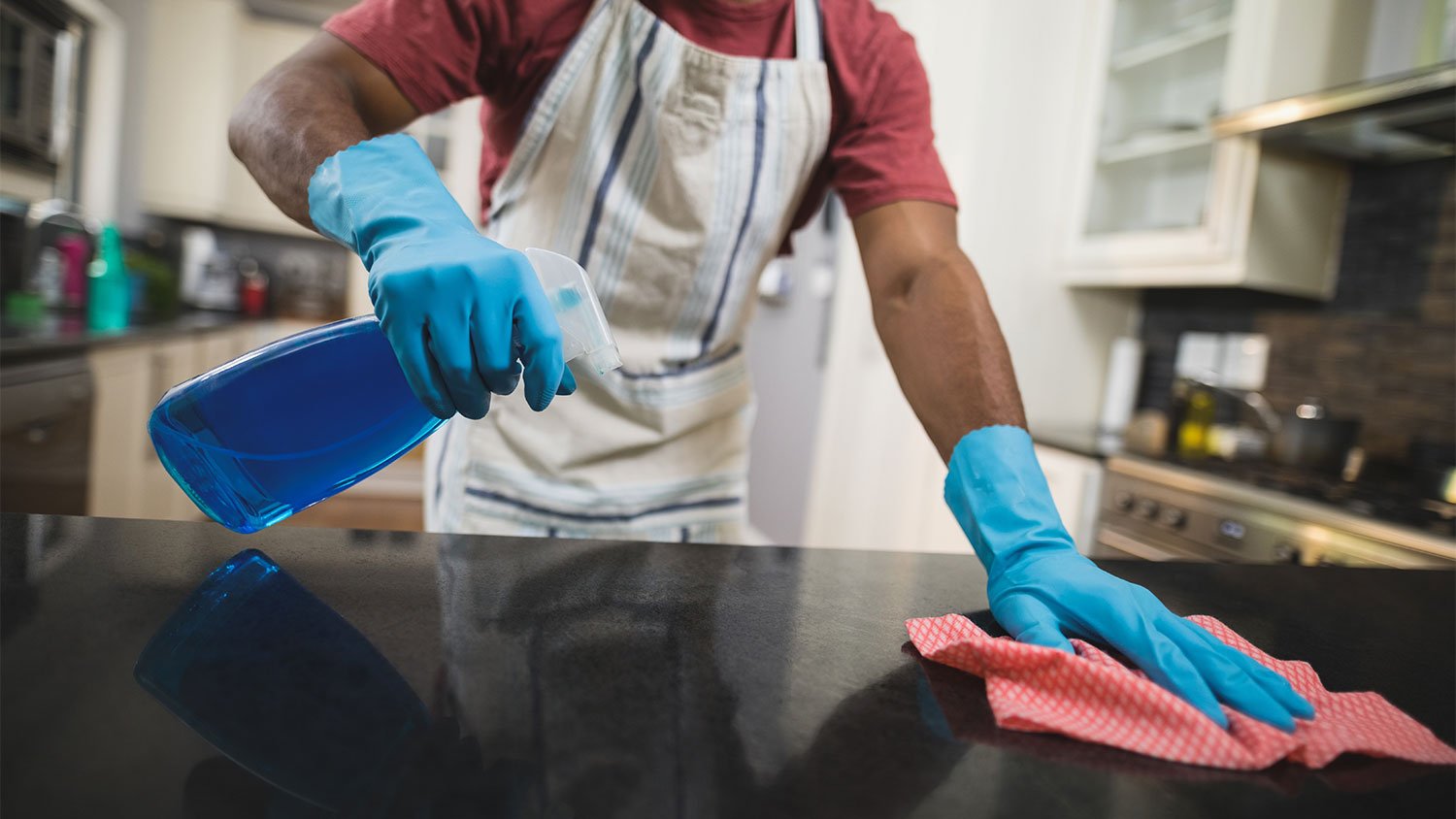 A man cleans a kitchen countertop