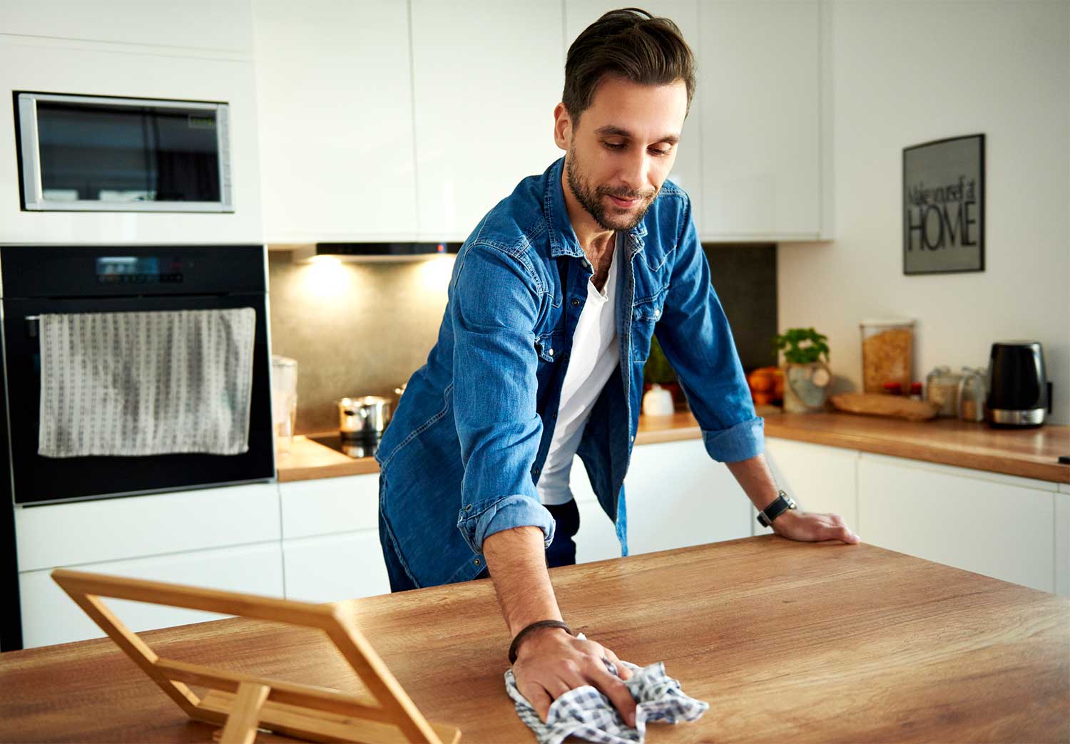 Man wiping kitchen counter with a rag