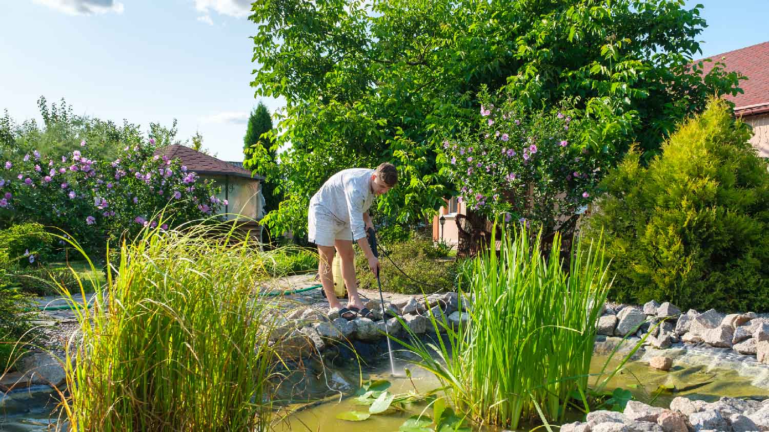 A man cleaning a pond