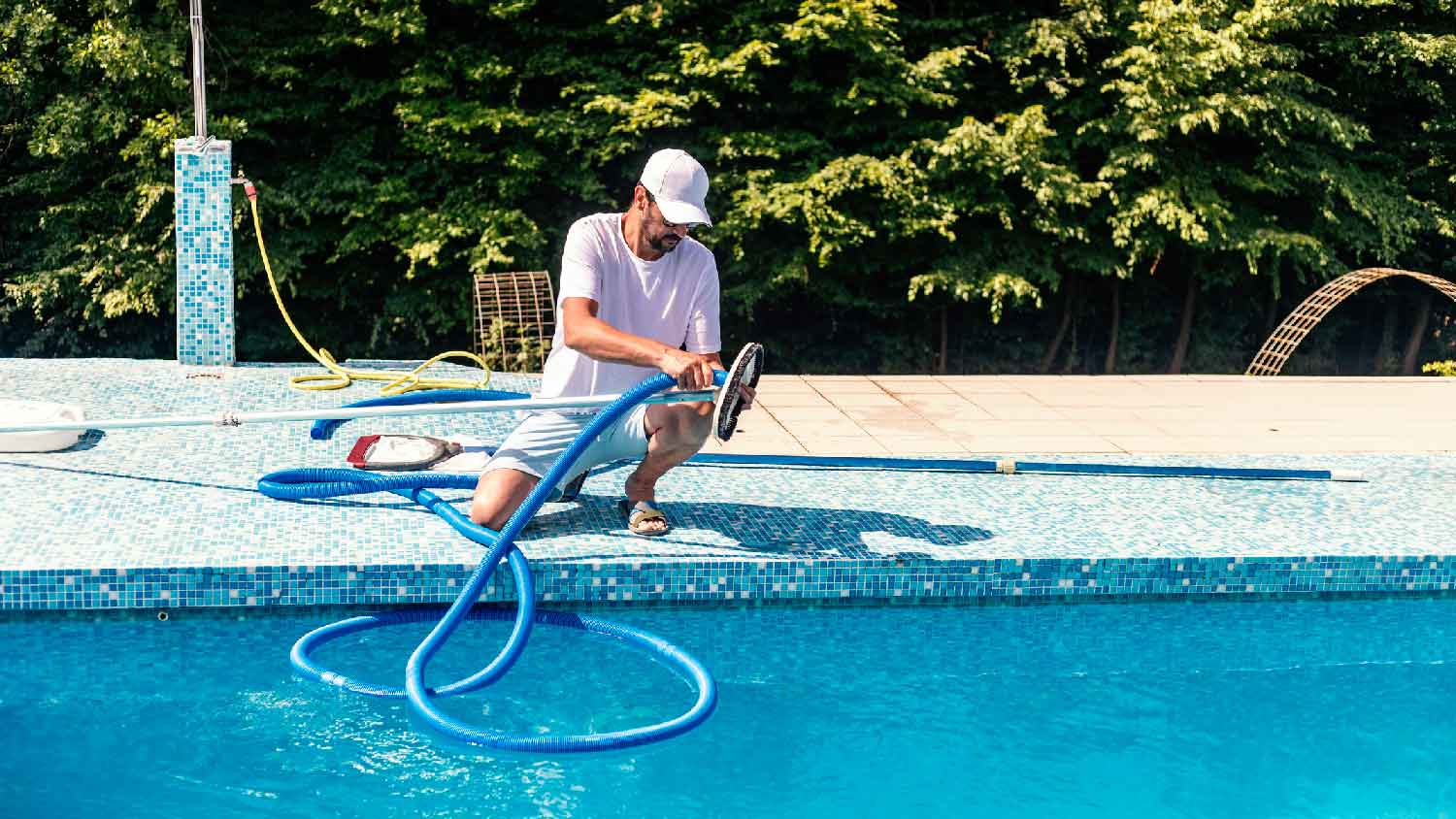 A man cleaning the pool