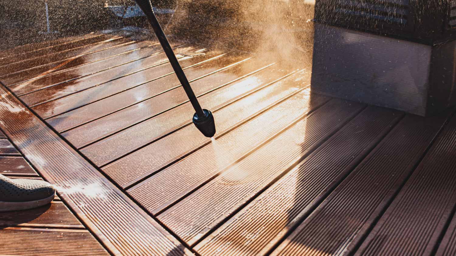 man cleaning terrace with a power washer