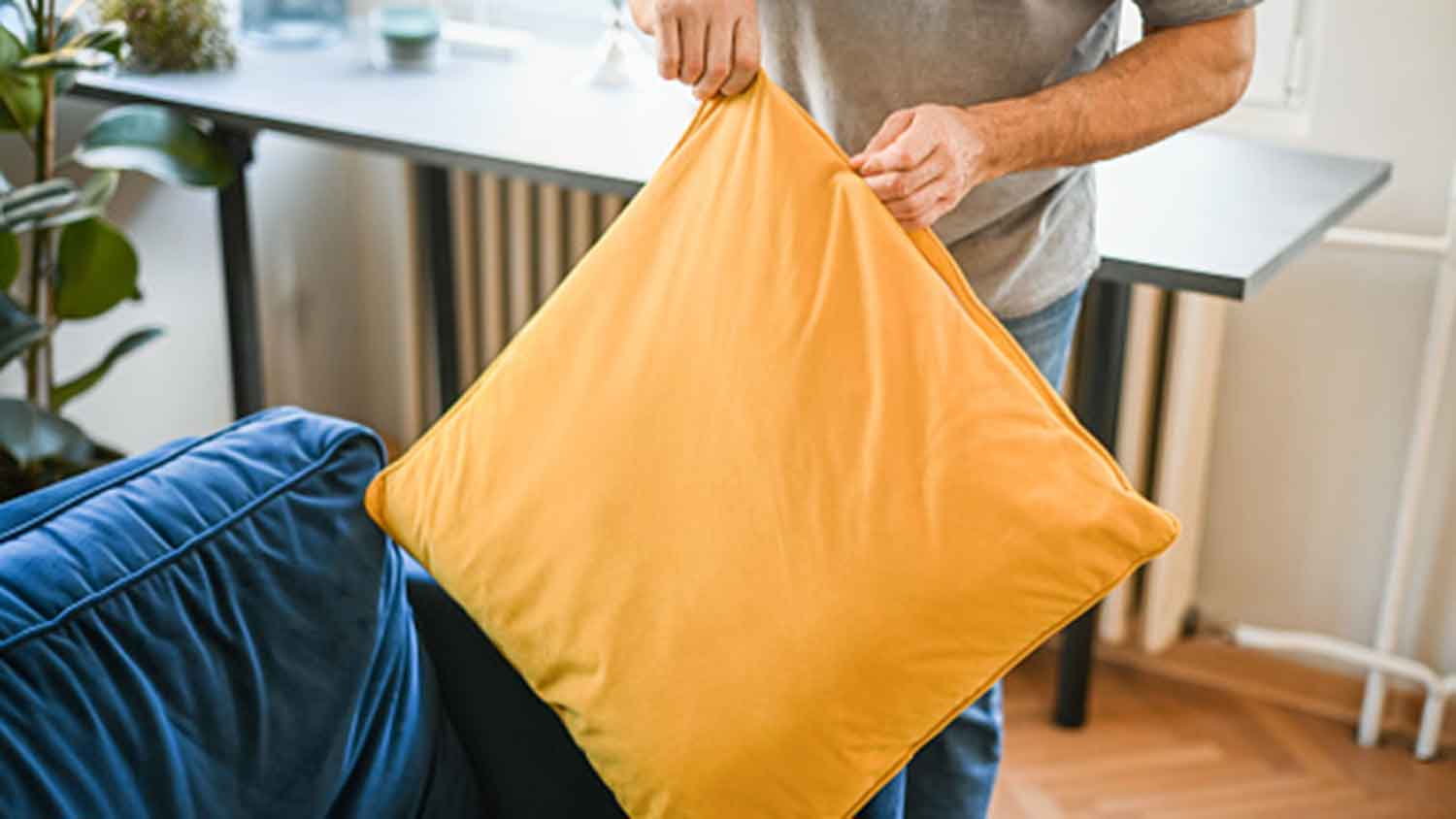 Man removing pillowcase from a couch pillow