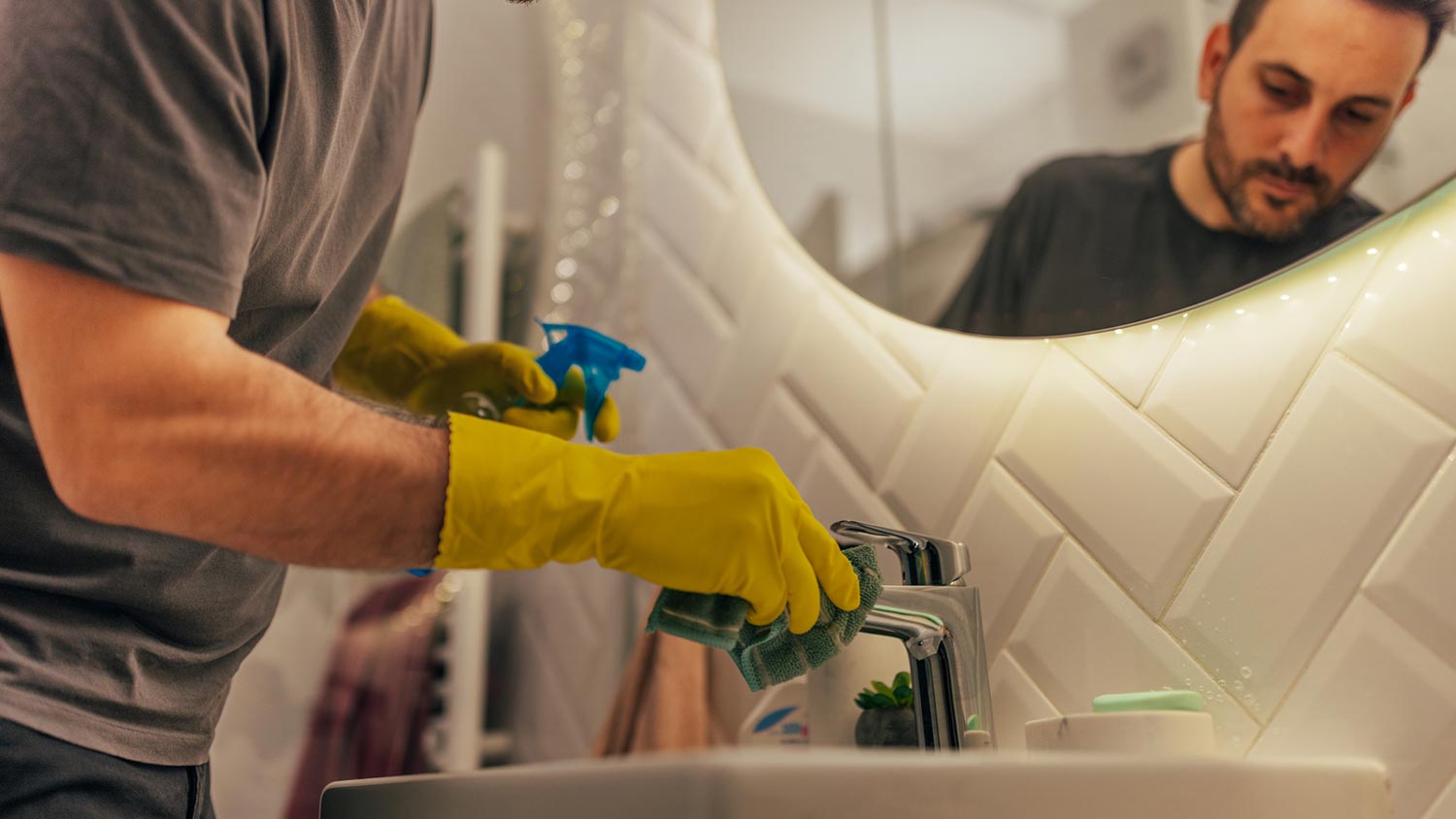 A man cleaning thoroughly a bathroom