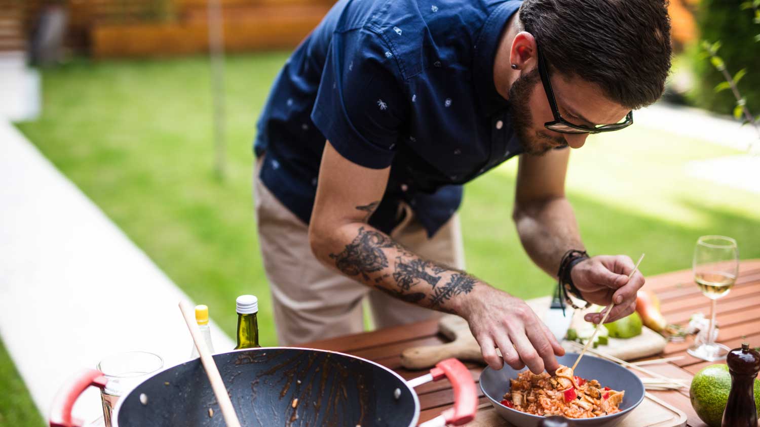 man cooking outside on grill