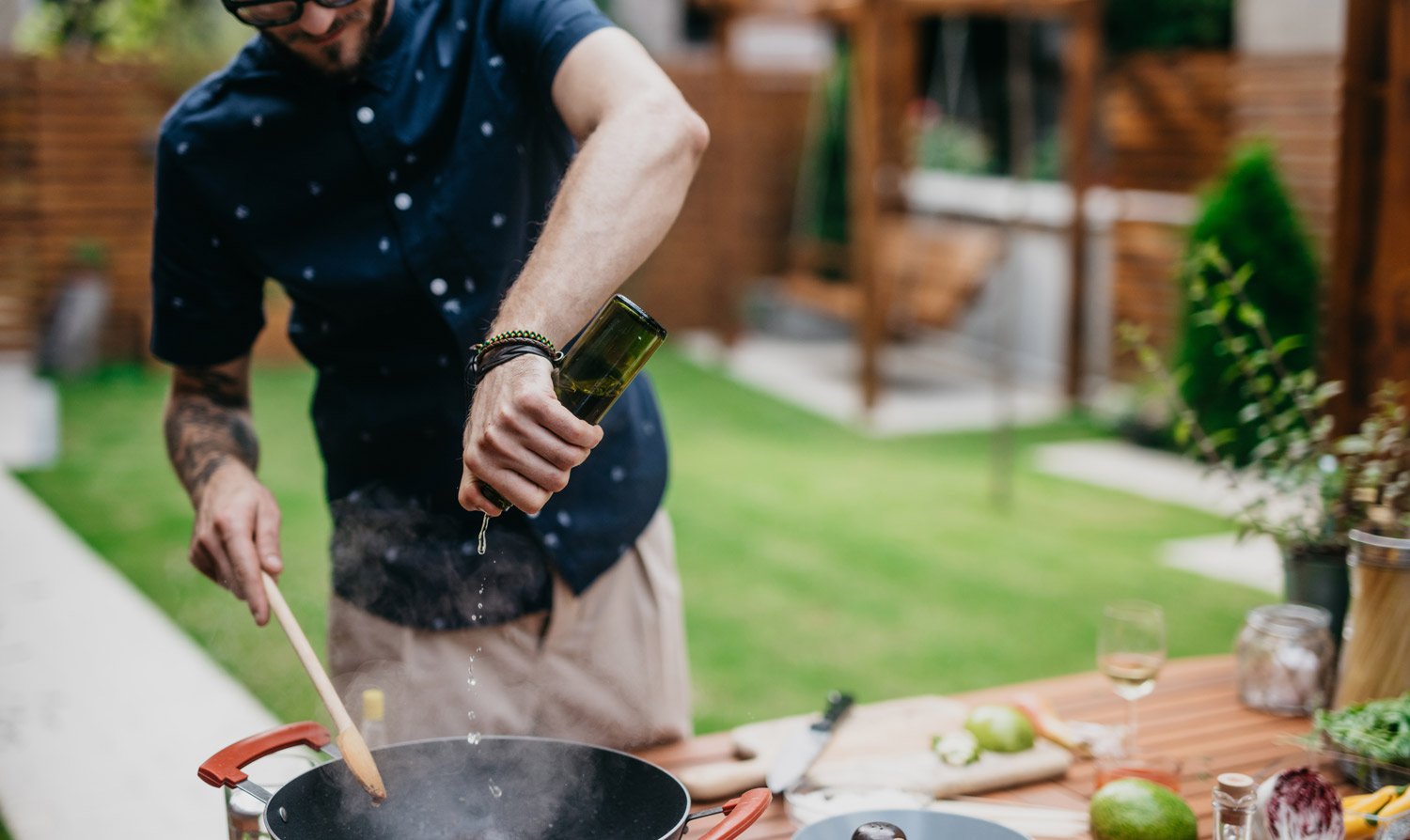 A man cooking a meal in an outdoor kitchen