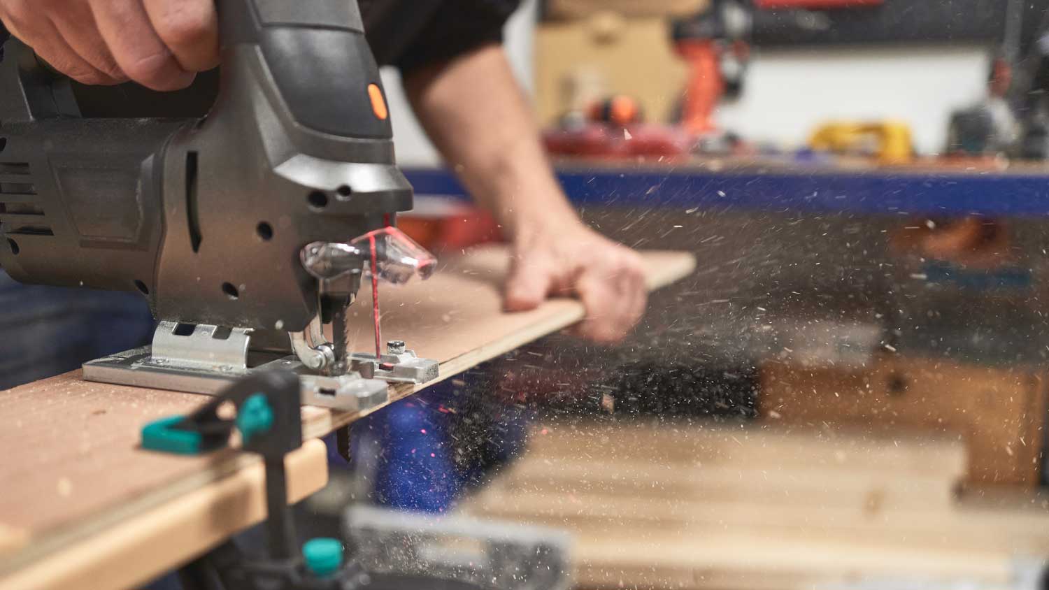 A man cutting a wooden plank with a cutting machine