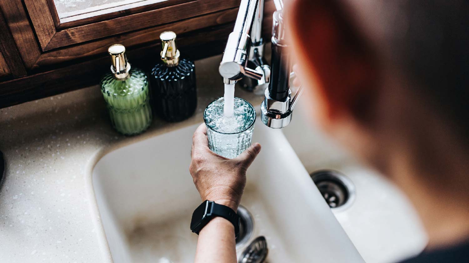 A man filling a glass with tap water