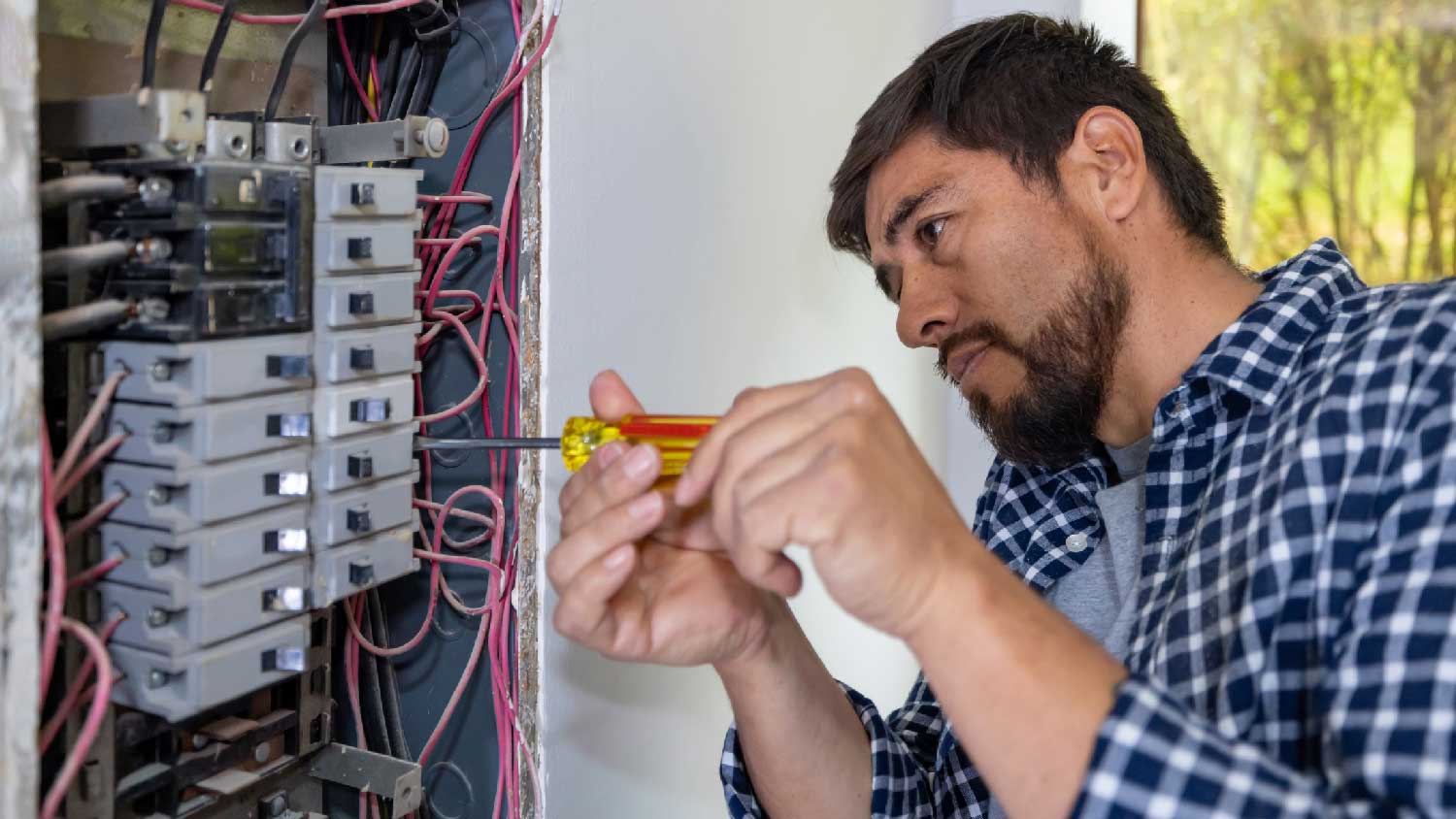 A man fixing a circuit breaker