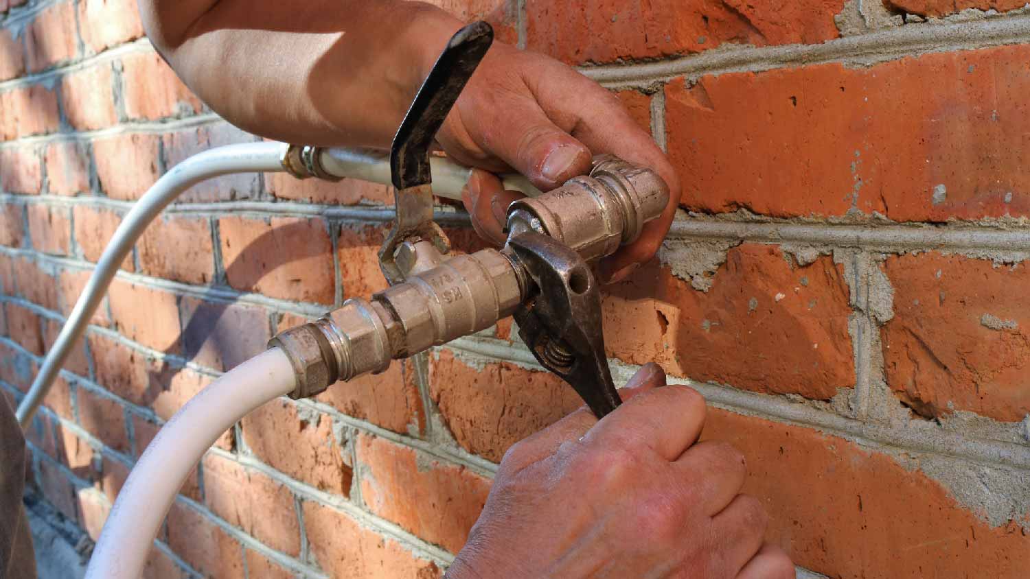 A man fixing a leaking pipe