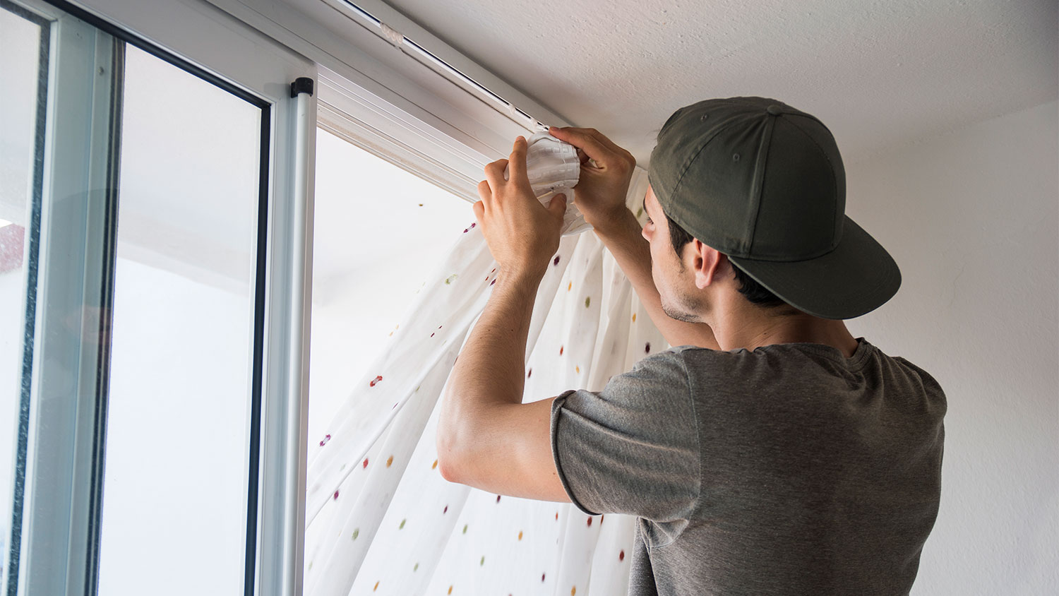 Man hanging curtains